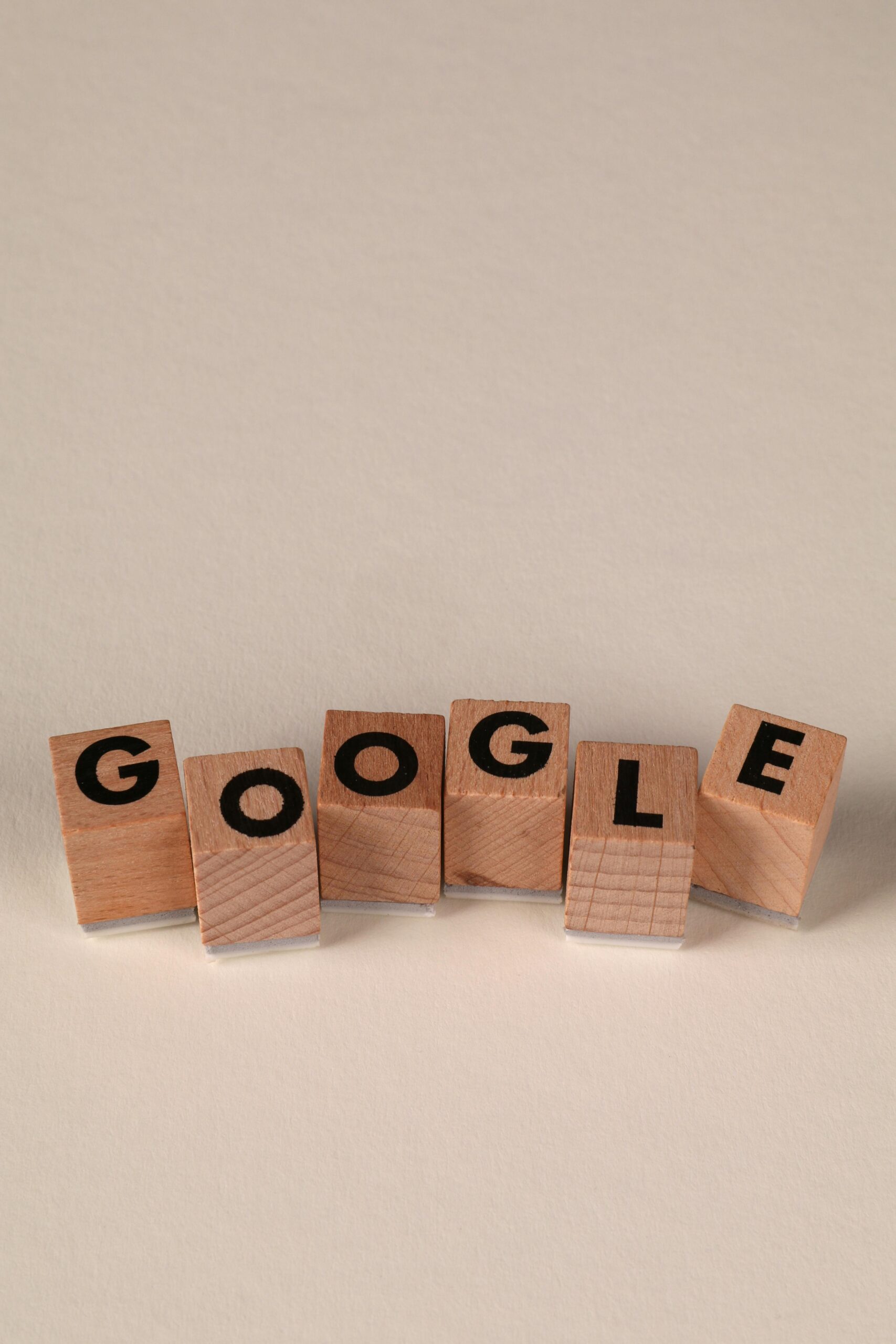 pexels photo 32319619 32319619 Wooden alphabet blocks forming the word 'Google' on a plain background, arranged playfully.
